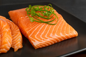 Slices of Raw Salmon Fillet on Black Background