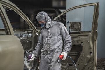 An employee of the paint shop prepares the car body for painting