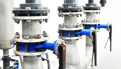 Large industrial water treatment and boiler room. A row of manual butterfly valves, flanges with...