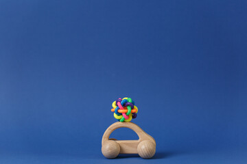 Colored rubber toy on a children wooden car.