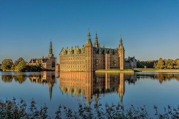 Frederiksborg Castle in a mirror-gloss reflection at surise