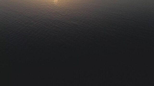 Sunrise/Sunset view over the ocean with woman standing in water
