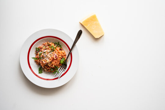 Risotto de betabel y calabaza con un trozo de queso parmesano reggiano