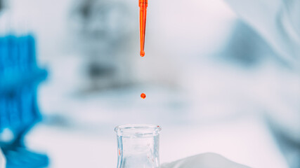 close up. background image of a drop of red liquid in a laboratory pipette.