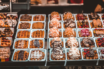 escaparate repleto de gofres belgas de todos los sabores con chocolate, fresas, nata, fruta