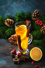 Christmas or New Year hot winter drink, spicy grog cocktail, punch or mulled wine with tea, lemon, rum, cinnamon, anise. Rustic style, festive table setting, copy space