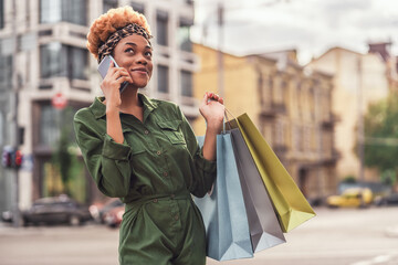 Happy pretty Afro American lady having a conversation on phone in the city