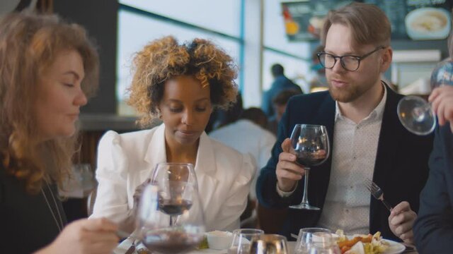 Close up of multiethnic people having lunch together in trendy cafeteria