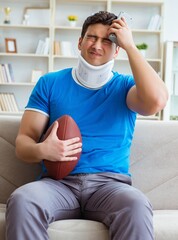 Man with neck injury watching american football at home