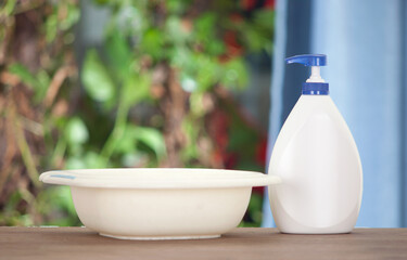 A bottle of hand sanitizer and a wash basin in the room