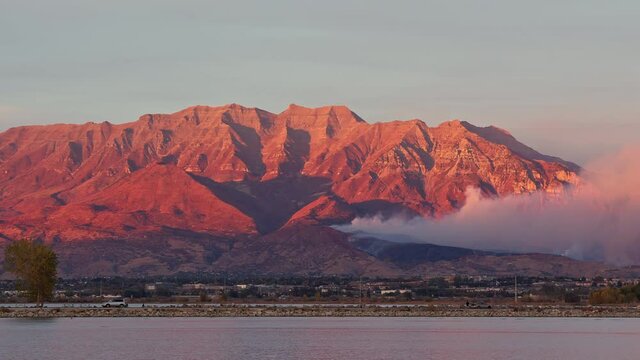 Panning Timpanogos Mountain during wildfire from Provo Harbor on Utah Lake at sunset.