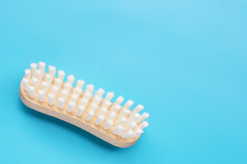 Wooden clothes brush on blue background.