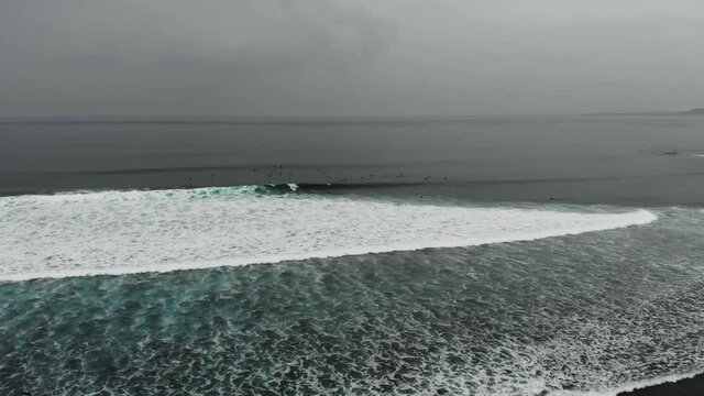 Surfer riding and turning with spray on powerful ocean wave. Surfing ocean lifestyle.Aerial tracking cinematic shot.