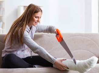 Young woman with broken leg at home
