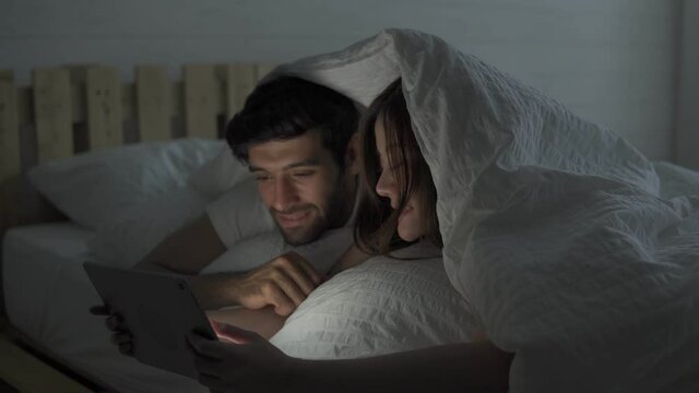 Footage b roll of Concept: technology, family, connection, Couple man and woman happiness using smart phone or tablet on bed in bedroom, Lifestyle technology concept. Happy couple.