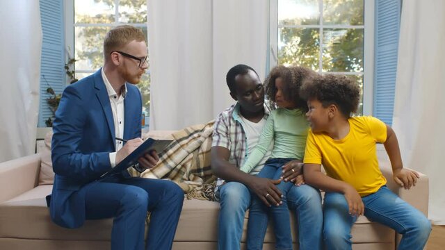 Portrait of social worker visiting single african father with two children