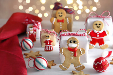 Obraz na płótnie Canvas Gingerbread man cookies with protective face mask and on Christmas decoration table. Christmas and new year concept in new normal. マスクをしたジンジャーマンクッキー クリスマスギフト