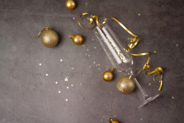 champagne glass and golden christmas decorations on dark background.