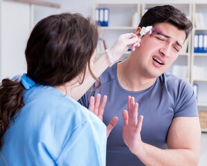 Young man visiting female traumatologist with black eye