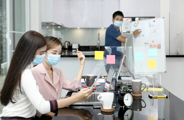 Fototapeta na wymiar Group of Asian business people meeting and working at home and wear mask for protect prevent infection covid 19.concecp social distance for New generation business