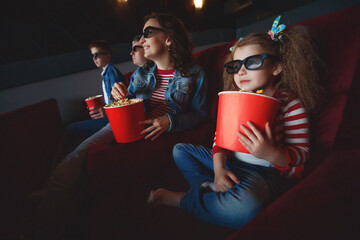Family mom father and children are watching a projector, TV, cinema, movies with popcorn in the...