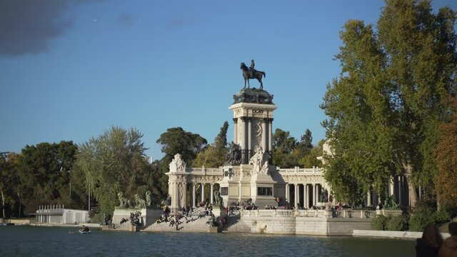 people gathering at Monument to Alfonso XII in the Parque del Buen Retiro - Park of the Pleasant Retreat in Madrid, Spain