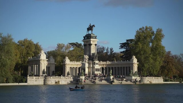 tourists on boats at Monument to Alfonso XII in the Parque del Buen Retiro - Park of the Pleasant Retreat in Madrid, Spain