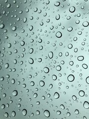 Image of water droplets on a clear glass surface during heavy rain.