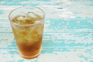glass of soft drinks on blue wooden table 