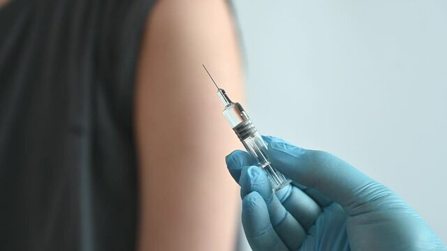 The doctor is injecting male patients. In the medical's hand have syringes.