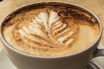 Cup of coffee cappuccino with a picture on the table