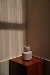 Composition Clay vase on red podium display with wall background in natural light scene concept. object /copy space