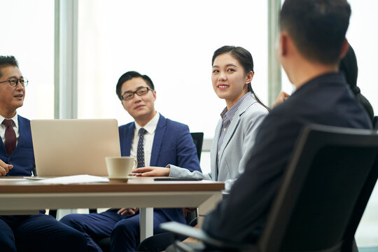 team of asian corporate executives discussing business in conference room
