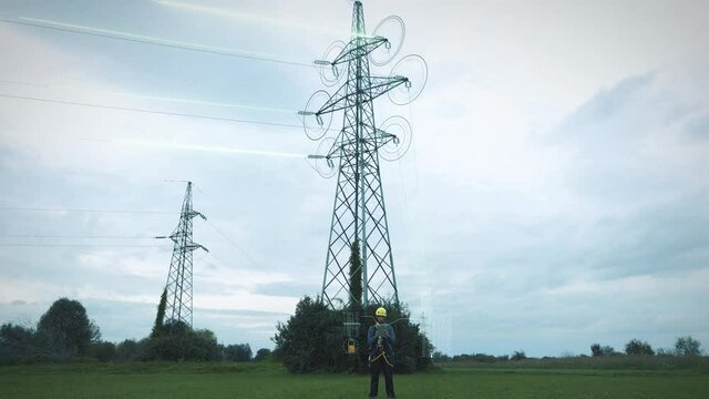 Engineer standing beside the electromagnetic towers with computerized animation of controlling and adjusting the frequency of emission of radiations.