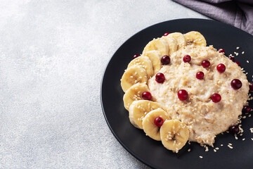 Oatmeal with milk with banana cranberries and sesame seeds. healthy Breakfast Concept. Copy space