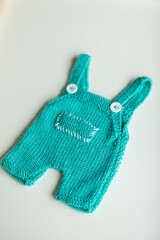  Various colors and types of cotton clothing, knitted newborn clothes and newborn hats on a white background.