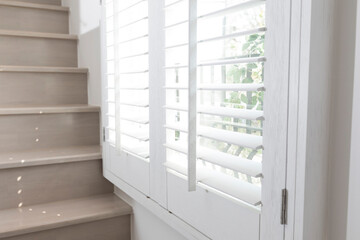 Closeup view of window with horizontal blinds. White Roller Blinds or Louver curtains at the glass...