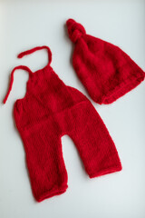  Various colors and types of cotton clothing, knitted newborn clothes and newborn hats on a white background.