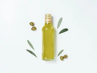 Foto op Canvas Olive oil glass bottle mock up. Top view of clear glass bottle with olive oil on white background with green olives and fresh green olive tree leaves. Copy space. © fascinadora