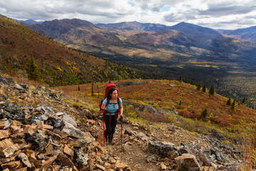 Girl Hiking up Scenic Rocky Trail in the Fall, surrounded by Mountains in Canadian Nature. Taken in...