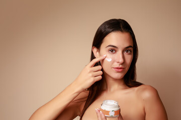 Joven Mujer mexicana aplicando crema humectante facial producto de belleza 