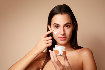 Joven Mujer mexicana aplicando crema humectante facial producto de belleza 