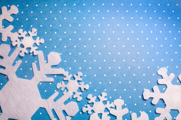 Happy New Year composition. Christmas or winter still life made of felt snowflakes on speckled blue background. Flat lay, top view, copy space.