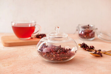 Jar with dry hibiscus tea on table