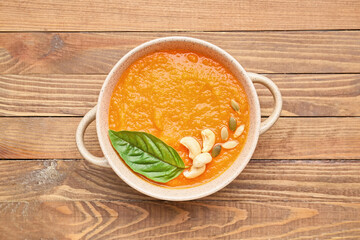 Tasty pumpkin cream soup in pot on table