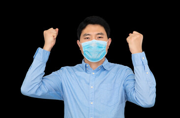 Man in mask standing in front of black background doing cheer with both hands