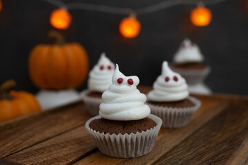 Halloween ghost cupcakes , homemade sweet chocolate muffins with meringue ghost