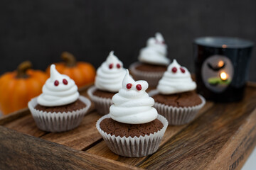 Halloween ghost cupcakes , homemade sweet chocolate muffins with meringue ghost