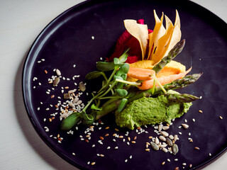 High resolution avocado sorbet with a flower decoration and seasoning, a restaurants dish, close up