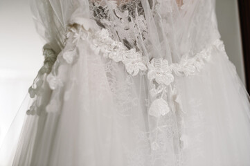Close-up part of the fashionable beautiful classic lace wedding dress. morning preparation wedding concept. Stylish vintage dress.